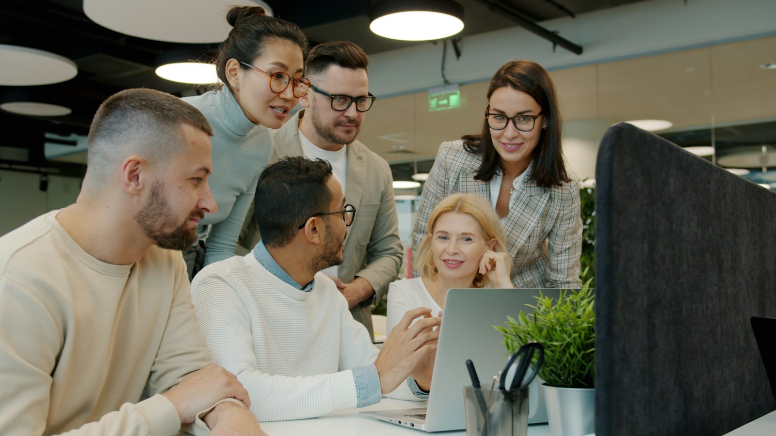Team collaborating around a laptop on a project